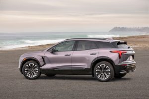 Side 7/8 view of the 2024 Chevrolet Blazer EV in Galaxy Gray Metallic parked in front of a beach.