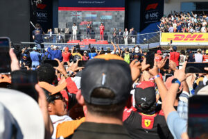 AUSTIN, TEXAS - OCTOBER 19: Race winner Max Verstappen of the Netherlands and Oracle Red Bull Racing Second placed Lando Norris of Great Britain and McLaren Third placed Charles Leclerc of Monaco and Scuderia Ferrari and Chris Gent, Chief Mechanic at Oracle Red Bull Racing on the podium during the F1 Grand Prix of United States at Circuit of The Americas on October 19, 2025 in Austin, Texas. (Photo by Michael Potts/LAT Images) // Getty Images / Red Bull Content Pool // SI202510200013 // Usage for editorial use only //