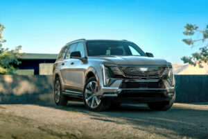 Front 3/4 view of the Cadillac ESCALADE IQL in Luna Metallic exterior color, showcasing Crystal Shield grille.